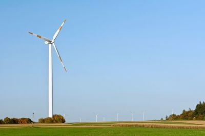 Windmill on field against clear sky