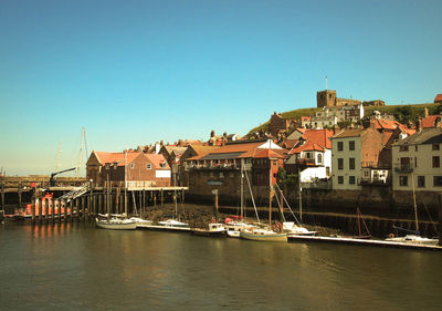 Boats in harbor with buildings in background