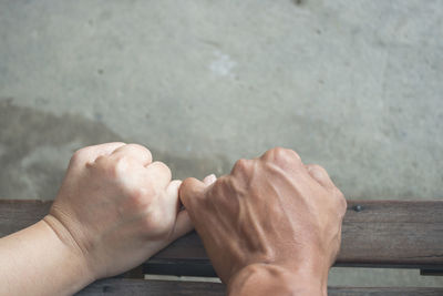 Cropped hands of couple taking pinky promise