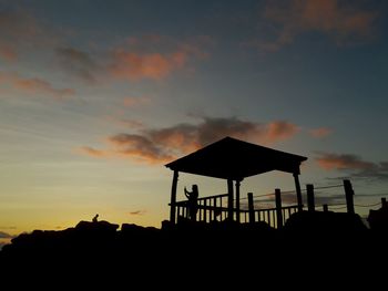 Silhouette boy against sky at sunset