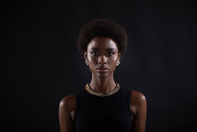 Portrait of a serious young woman over black background