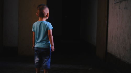 Rear view of boy standing in building