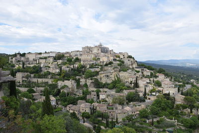 Buildings in town against cloudy sky