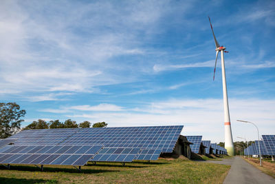 Wind turbines on field against sky