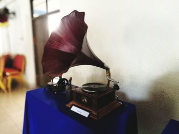 Close-up of electric lamp on table against wall