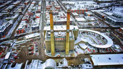 High angle view of an old chimney in a trash burning  factory, cars on snow covered city