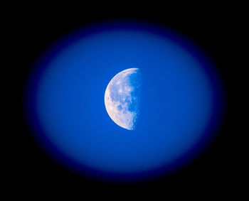 Low angle view of moon against blue sky