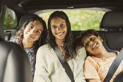 Portrait of smiling friends sitting in car