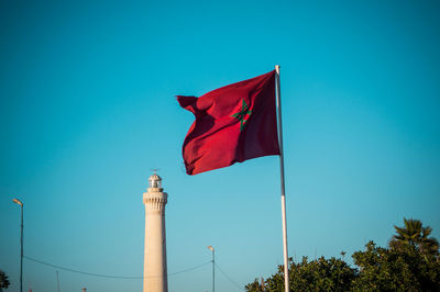 Low angle view of flag against blue sky