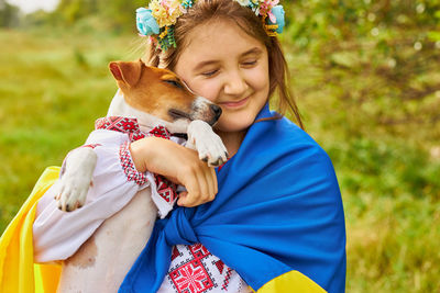 The ukrainian girl hugs her dog.