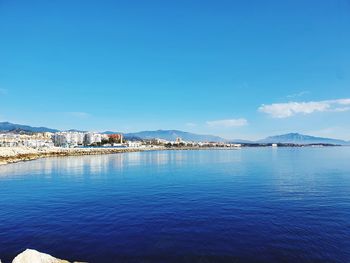 Scenic view of sea by city against sky