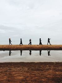 People on beach against sky