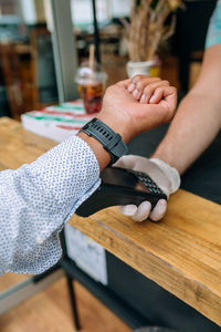 Man making contactless payment through smart watch at restaurant