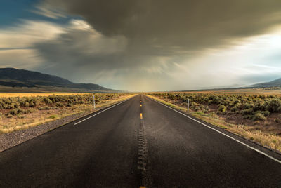 Long straight road in utah with dramatic clouds and rain rolling in