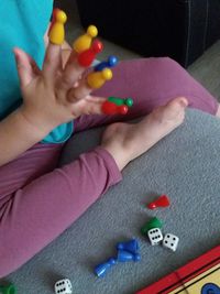 Low section of baby playing with toy