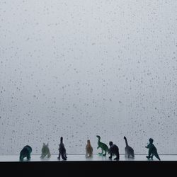 Silhouette people on snow against sky