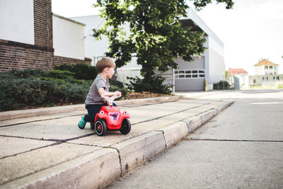 Cute boy riding toy in city