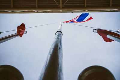 Low angle view of flags hanging against sky