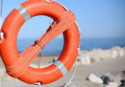 Orange lifebuoy for people near rocks at the sea in summer