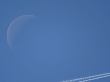 Low angle view of moon against blue sky