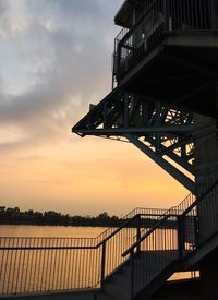 View of bridge over calm lake at sunset