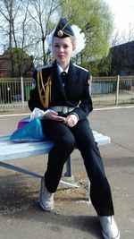 Portrait of smiling young woman sitting in park