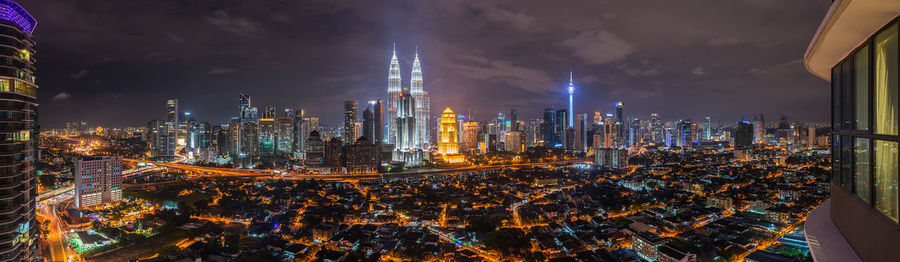 Panoramic shot of illuminated petronas towers in city at night