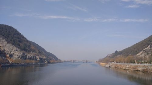 Scenic view of lake by mountains against sky