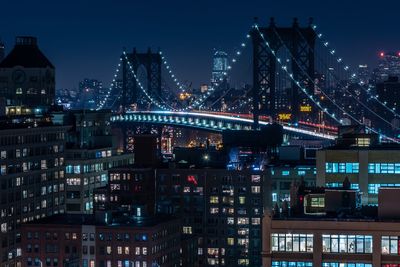 Illuminated cityscape against sky at night