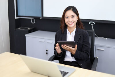 Portrait of businesswoman using digital tablet in office