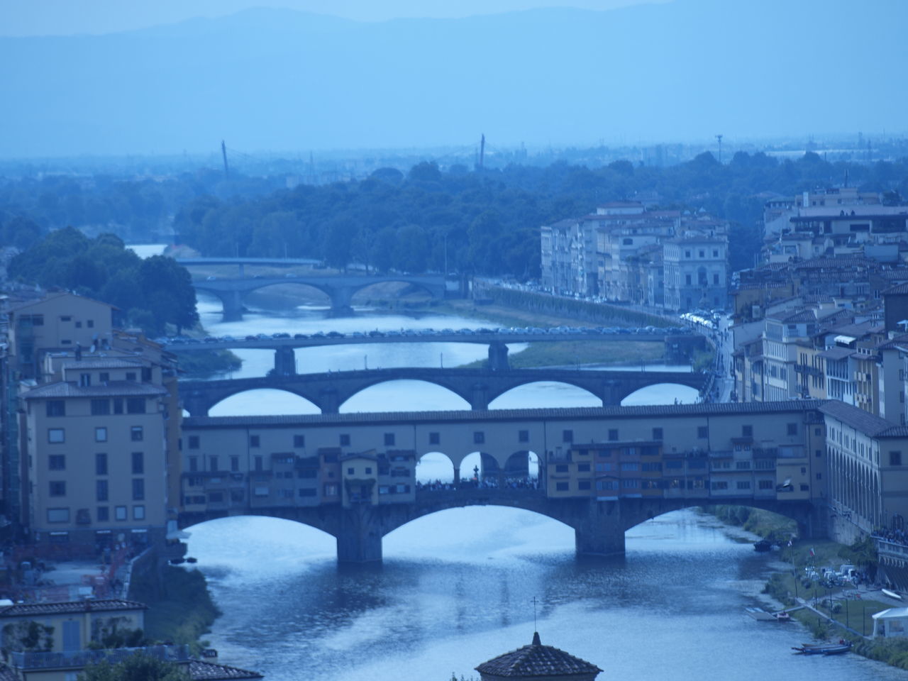 BRIDGE OVER RIVER IN CITY AGAINST SKY DURING WINTER