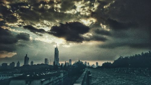 Silhouette of buildings against cloudy sky