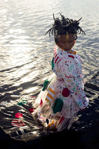 Rear view of girl with arms raised in water