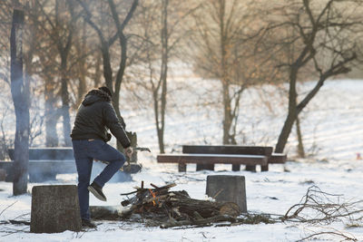 Man working on snow covered tree