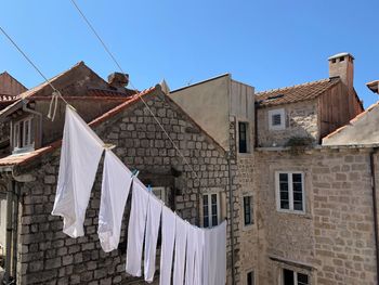 Low angle view of clothes drying on building against sky