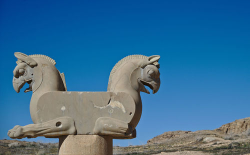 Low angle view of statue against clear blue sky