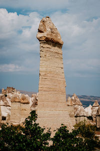 View of rock formation against cloudy sky