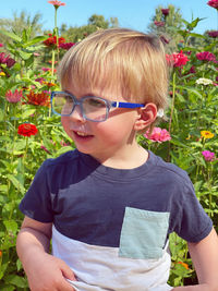 Portrait of young woman standing against plants