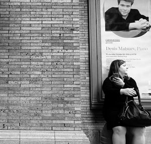 Woman standing against brick wall