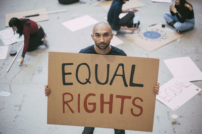 Bald man with equal rights sign standing in building