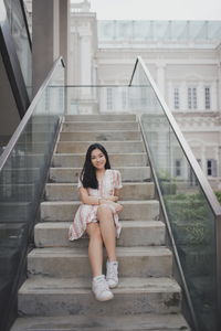 Portrait of young woman sitting on staircase