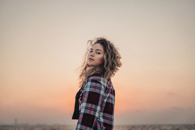 Portrait of woman standing against sky during sunset