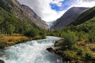 Scenic view of river amidst mountains against sky