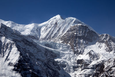 Scenic view of snowcapped mountains against clear sky