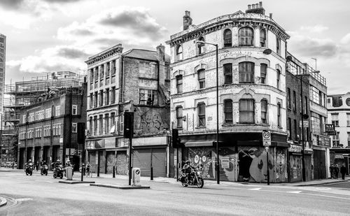 Buildings in city against cloudy sky