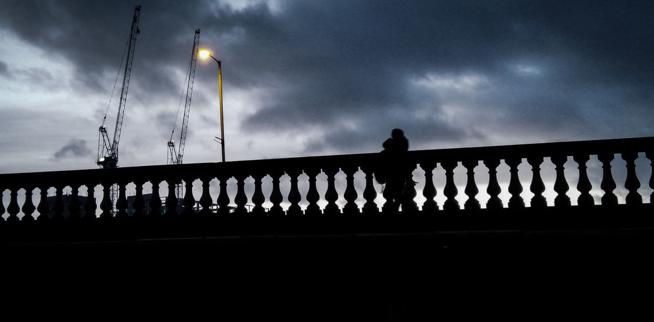 LOW ANGLE VIEW OF SILHOUETTE BRIDGE AGAINST CLOUDY SKY