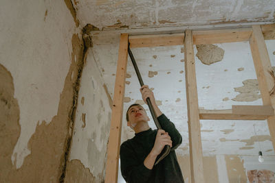 Portrait of woman standing against wall