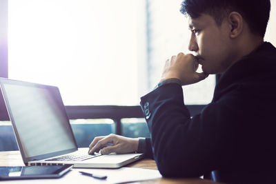 Rear view of man working on table