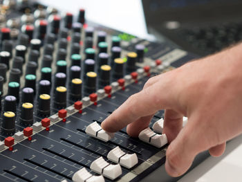 Cropped hand of man mixing music in recording studio