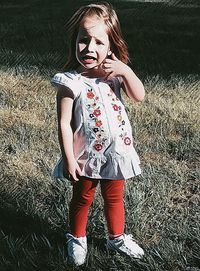 Portrait of teenage girl standing on field